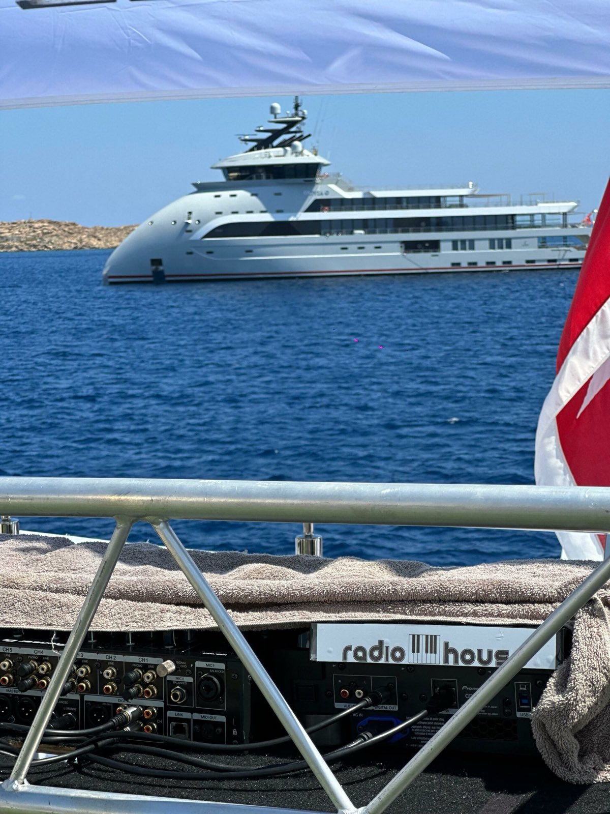 Superyacht anchored off Mykonos seen from the deck of a charter boat