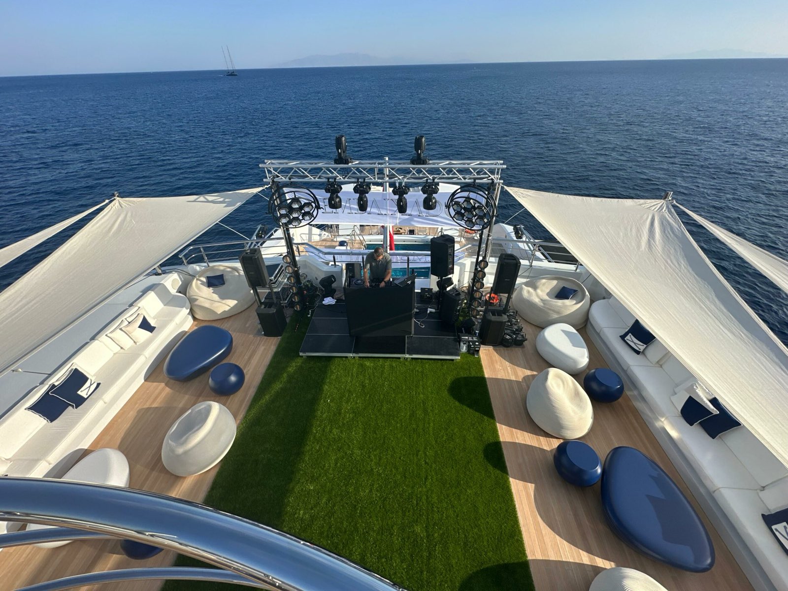 DJ stage with truss and lighting on the bow deck of a yacht at sea off Mykonos, seen from above