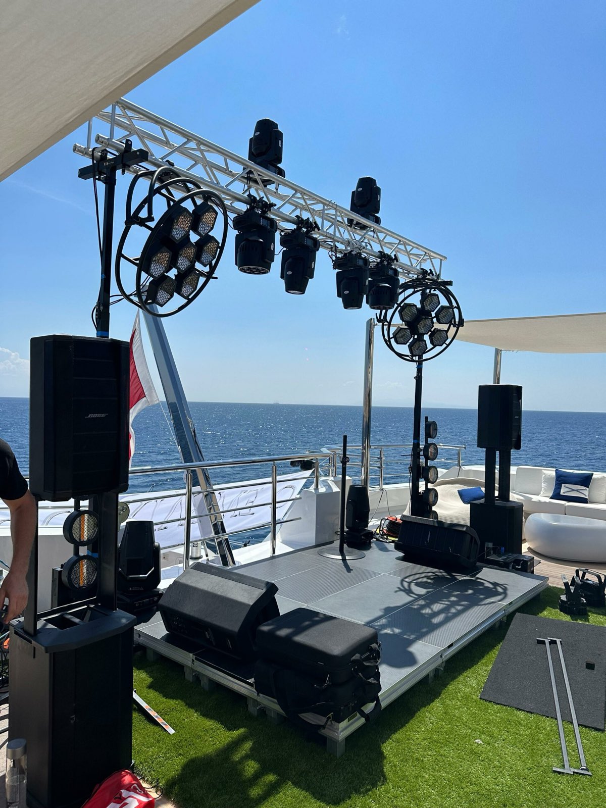 Speakers and a truss with moving-head lights rigged on a yacht deck off Mykonos